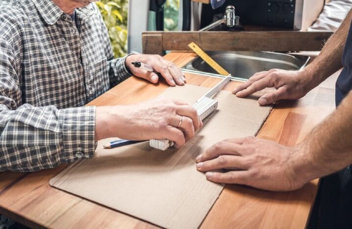 Arbeiter messen Arbeitsplatte aus