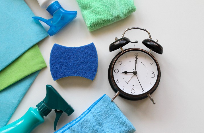 Putzmittel Handschuhe Schwamm Uhr Wecker Planen Konzept