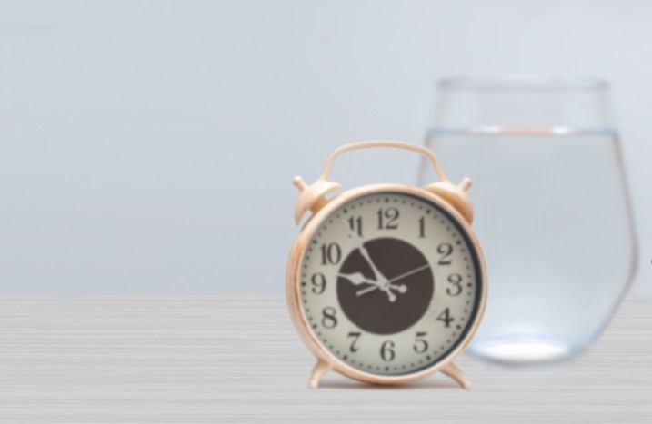 Wecker steht vor Wasserglas
