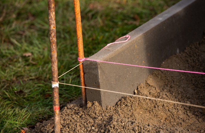 Mit Stangen und Schnüren abgesteckte Fläche für ein Fundament.
