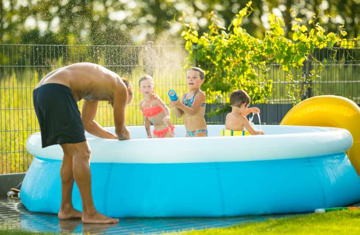 Vater und Kinder spielen in Pool