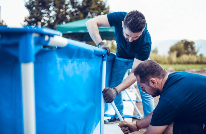 Männer bauen Pool auf