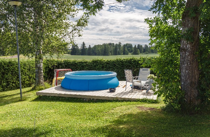 Aufbaupool in Garten auf Holzuntergrund