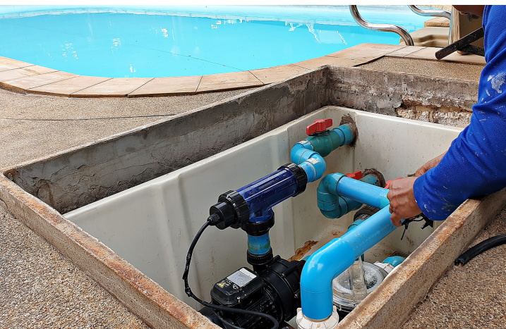 Mann reinigt Poolpumpe