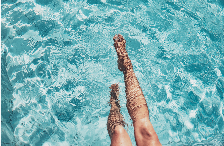 Beine in klarem Poolwasser