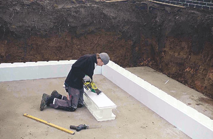 Handwerker schneidet Styroporsteine zu.