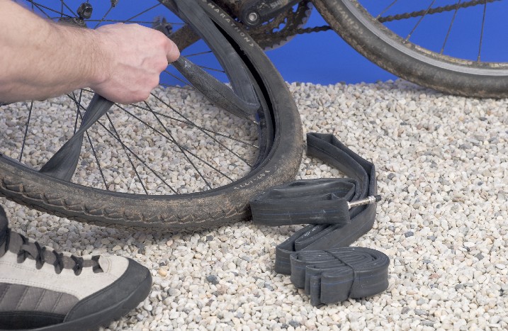 Nahaufnahme eines Fahrradschlauchs, während er vom Reifen gelöst wird.