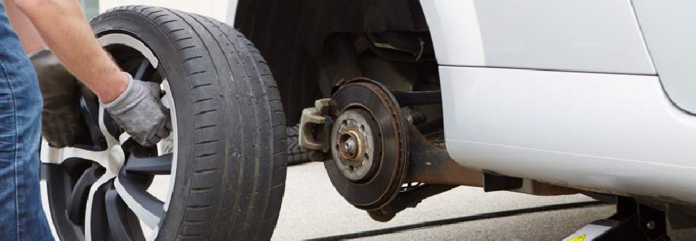 Person wechselt einen Autoreifen