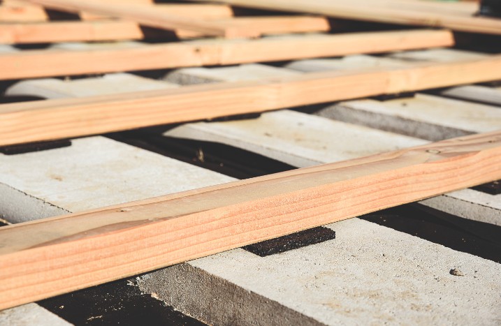 Leisten für die Unterkonstruktion einer Holzterrasse auf Betonplatten.
