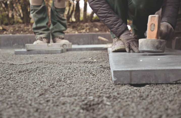 Steinplatten werden mit Gummihammer verlegt