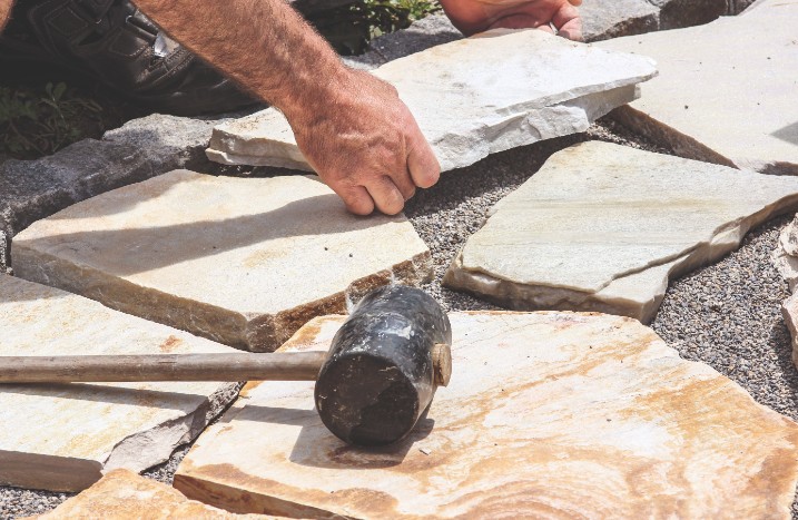 Steinterrasse wird aus Polygonalplatten gebaut