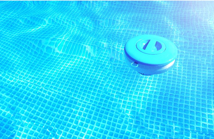 Ein Behälter für Chlortabletten schwimmt im Swimmingpool.