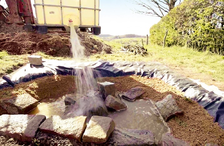 Der Tümpel wird mit Sand und dann mit Wasser gefüllt.