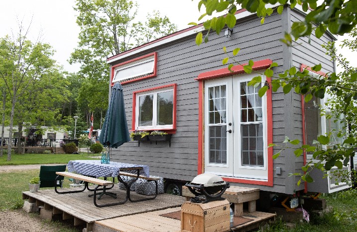 Ein Tiny House mit Terrasse im Grünen.