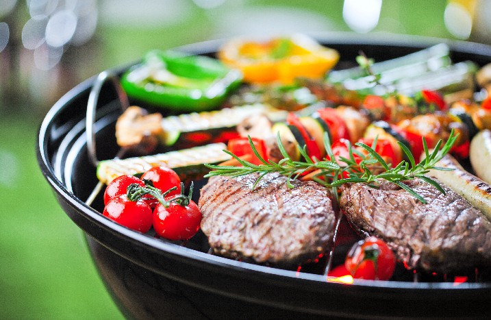 Verschiedenes Gemüse und Fleisch auf einem Grill.