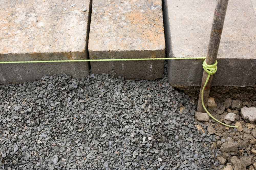 Richtschnur zum Verlegen von Pflastersteinen auf einem Schotterbett.