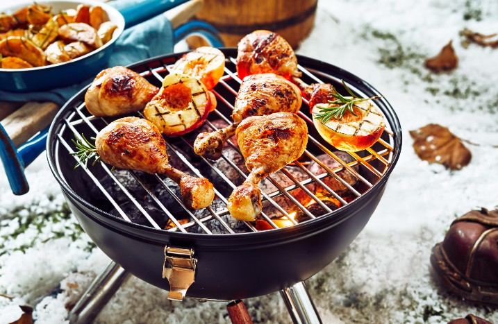 Kugelgrill im Schnee befüllt mit Essen