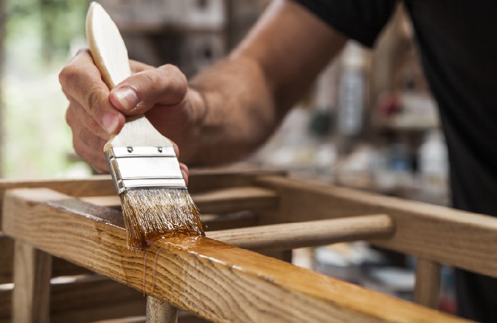 Holz wird mit Pinsel gestrichen