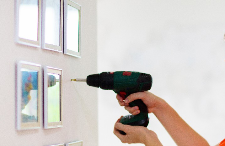 Schraube wird mit Akkubohrer in der Wand befestigt.