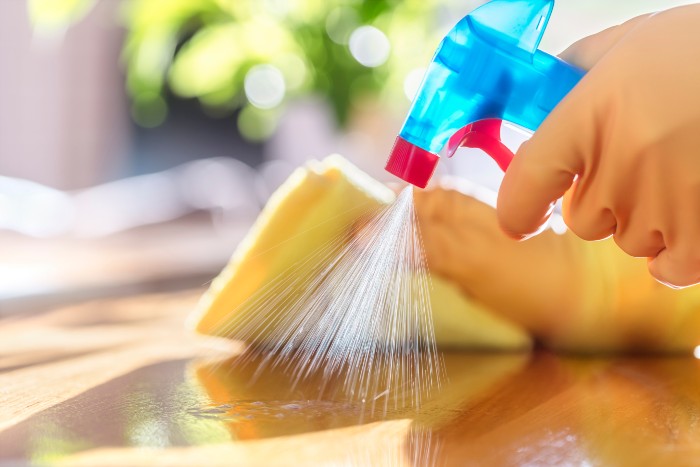 Holztisch wird mit Spray gereinigt