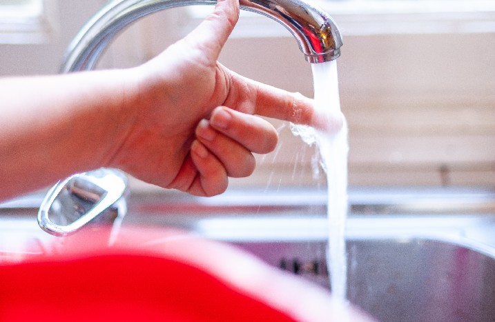 Heißes Wasser wird in einen roten Eimer gefüllt