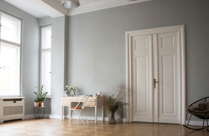Heller Raum mit Schreibtisch und Flügeltür