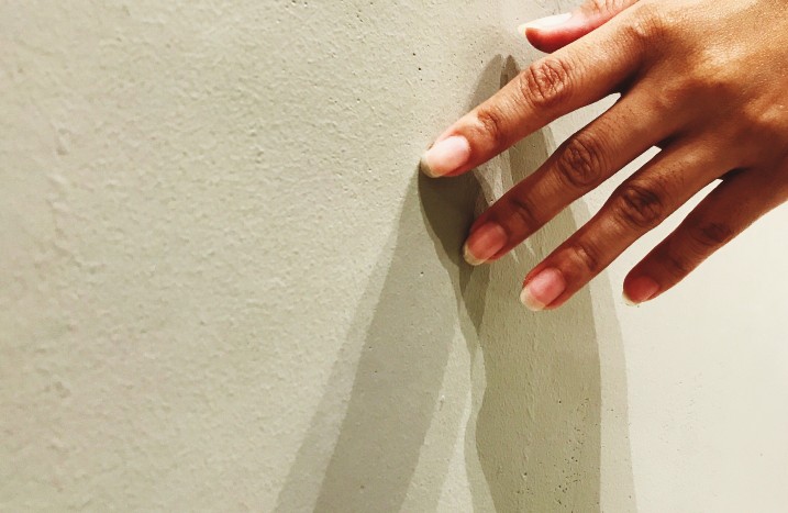 Hand streicht über Wand