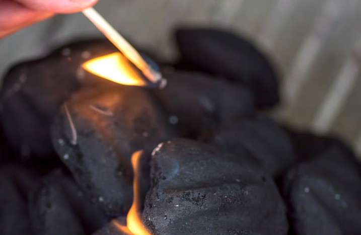 Holzkohle mit Streichholz anzünden