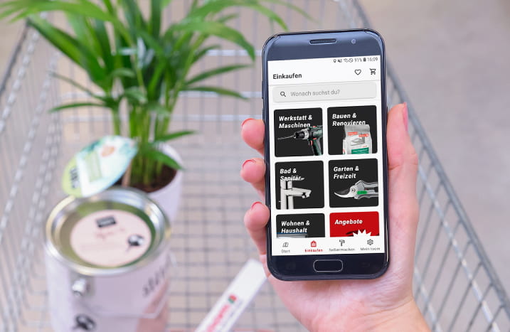 Handy über einem Einkaufswagen mit Sortimentsübersicht
