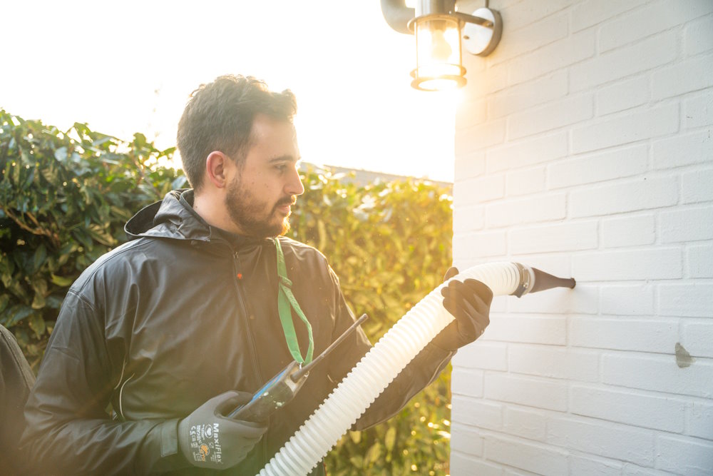 Ein VARM-Mitarbeiter führt eine Einblasdämmung durch