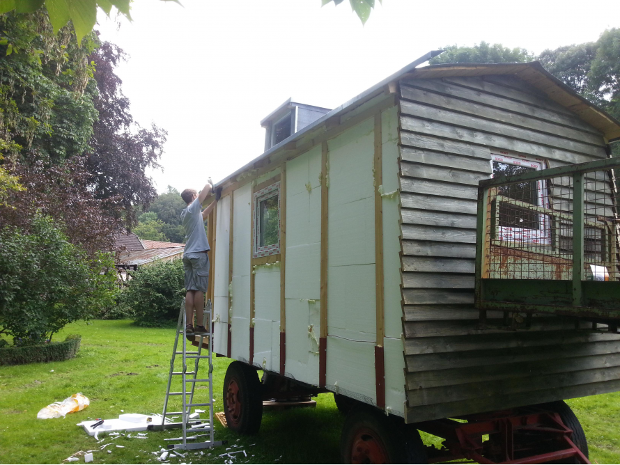 Person baut einen Bauwagen