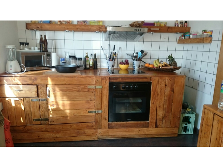 Eine rustikale Küche mit Holzarbeitsplatte und -regalen.