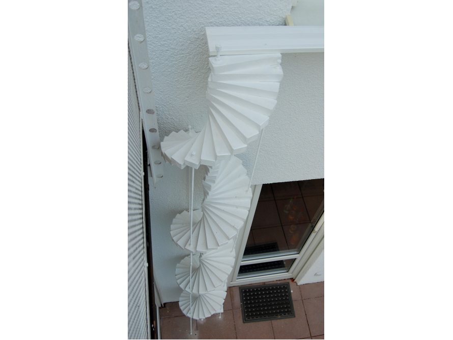 Weiße Wendeltreppe an Hauswand