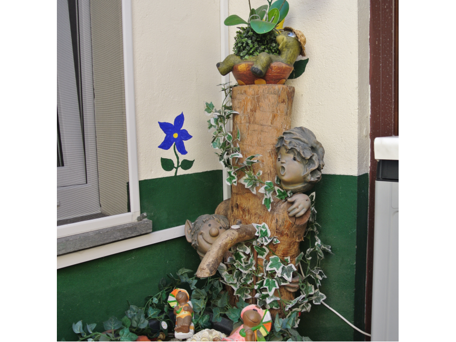 Zwei Gartenzwerge an einem Baumstamm