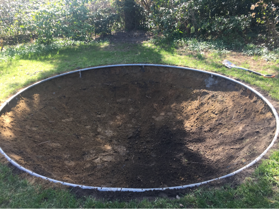 Rundes Loch mit Rahmen im Rasen