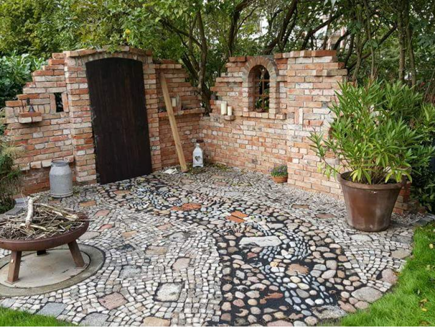 Gepflasterter Sitzplatz mit Backsteinmauer im Garten