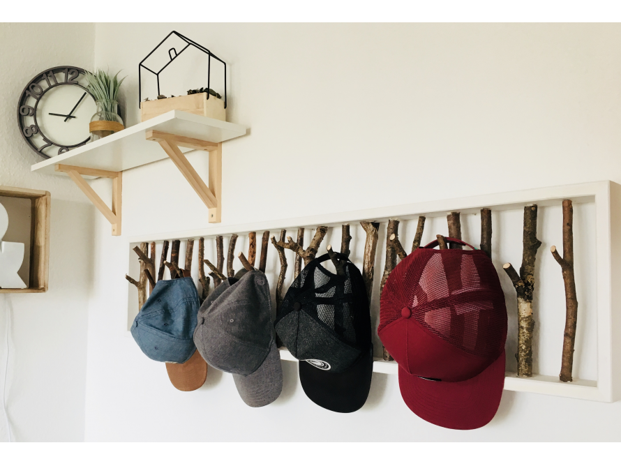 Mützen auf einem Kleiderhaken aus Ästen