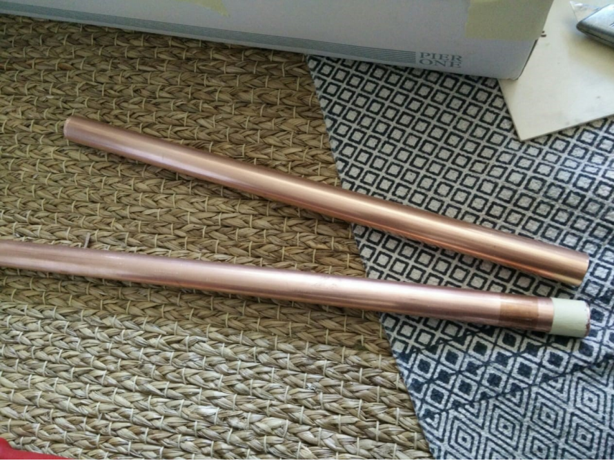 Zwei Kupferrohre auf einem Teppich.