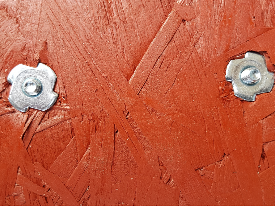 Zwei Schrauben auf rohem Sperrholz