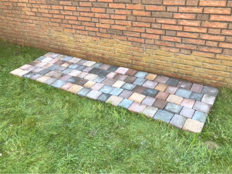 Gepflasterte Fläche vor Backsteinmauer