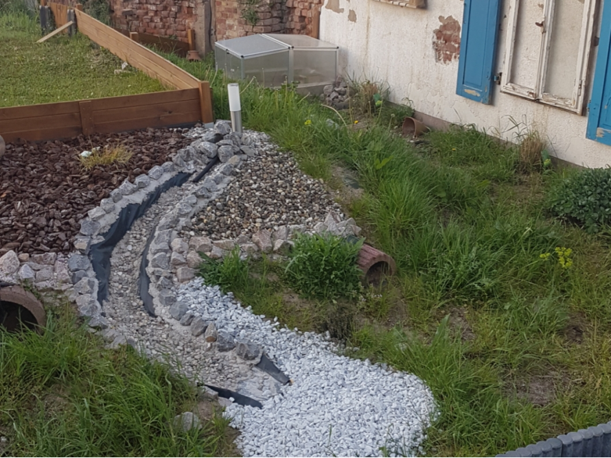 Kiesbett eines Bachlaufs im Garten