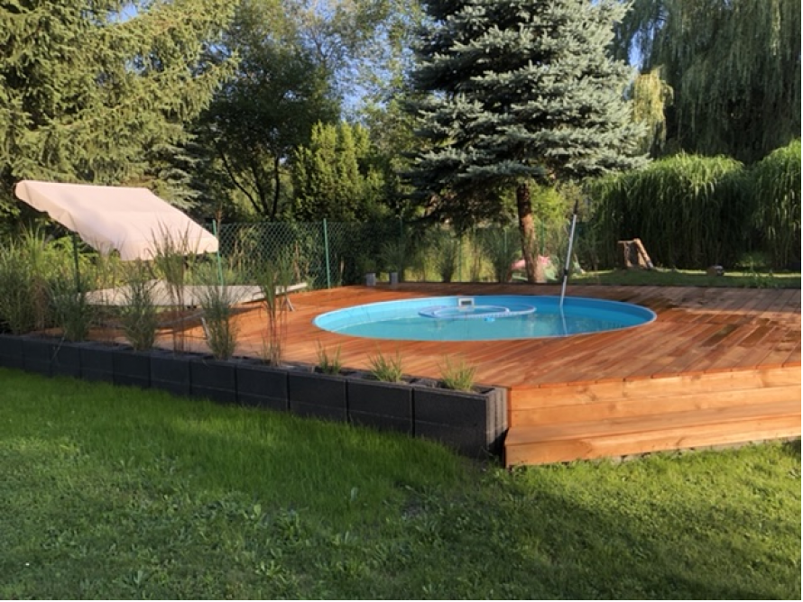 Runder Pool auf Holzterrasse im Garten