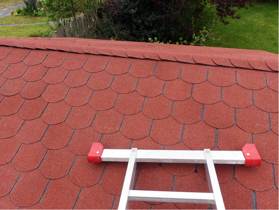 Rote Dachschindeln und Leiter