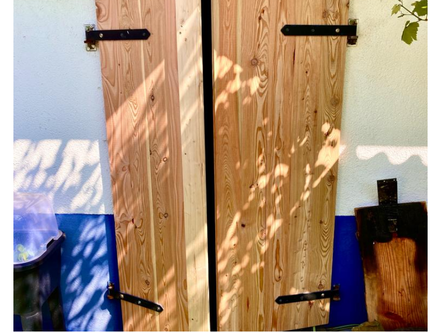 Zwei Holztüren mit schwarzen Scharnieren