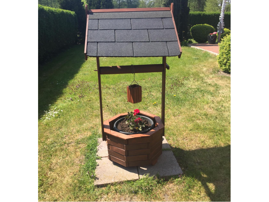 Dekorativer Holzbrunnen mit Blumen