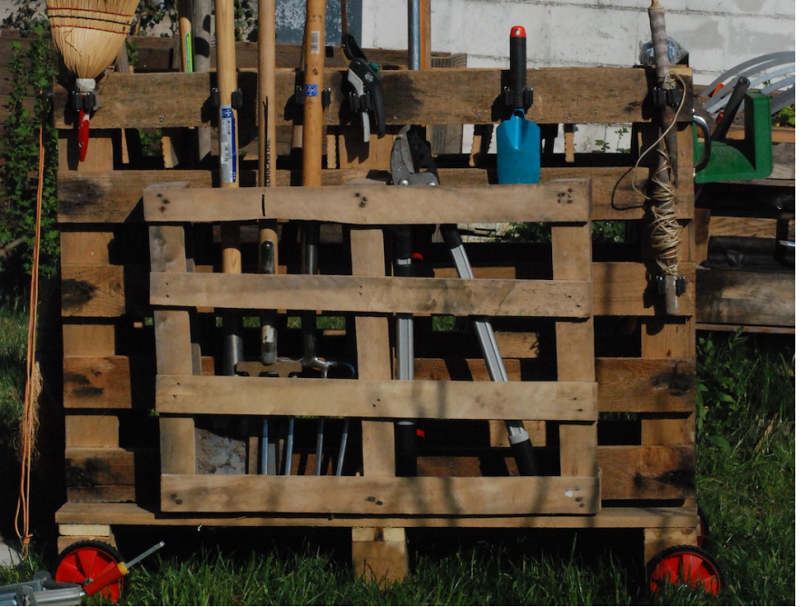 Gartenwerkzeug an einer Palette aufbewahrt
