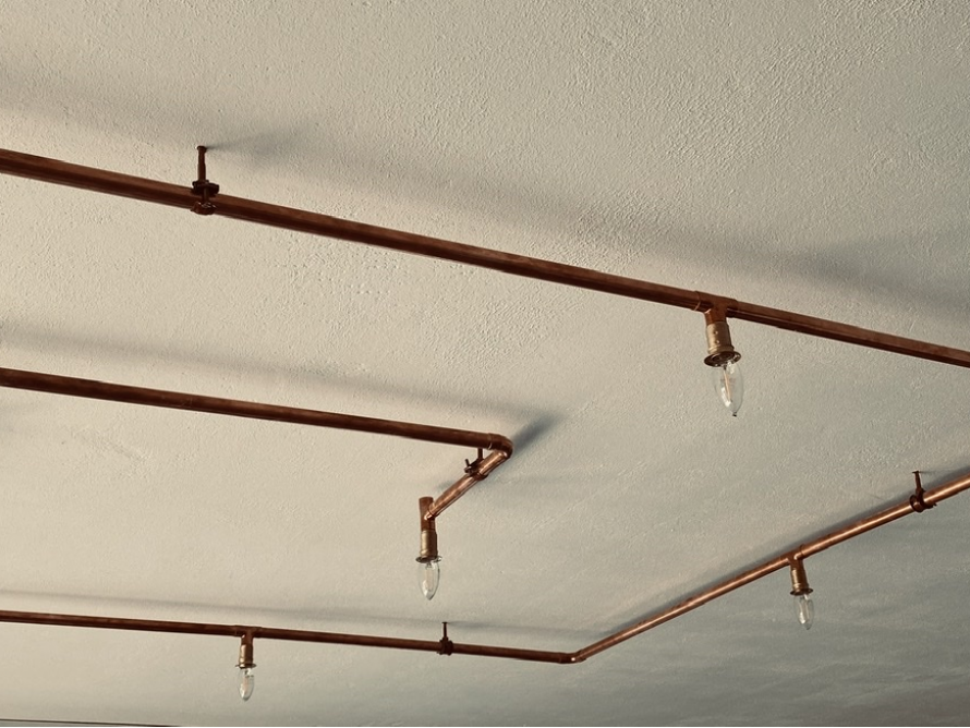 Kupferrohre mit Glühbirnen an Decke