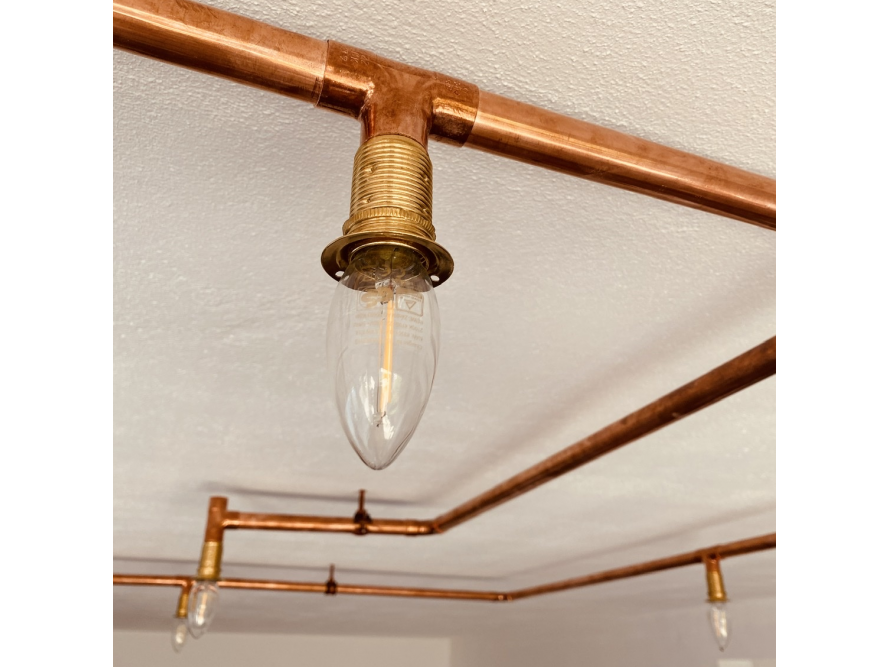Kupferrohre mit Glühbirnen als Deckenbeleuchtung