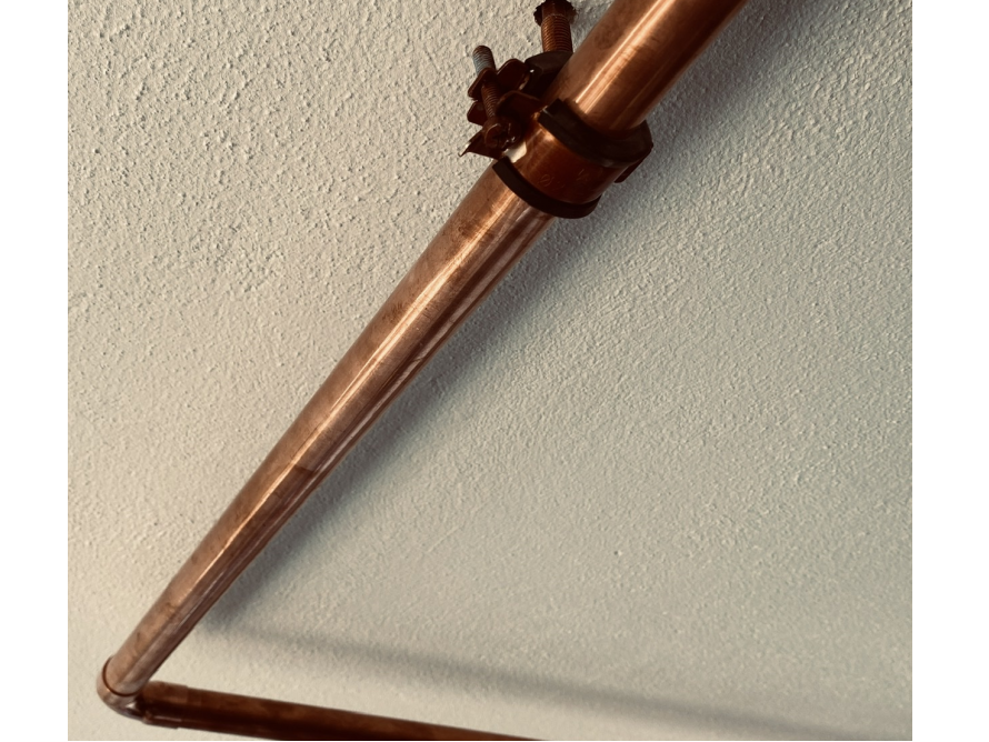 Kupferrohr an Wand befestigt