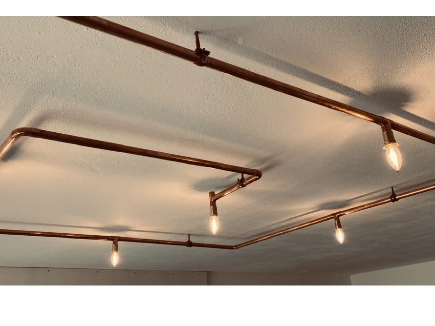 Industrielle Deckenbeleuchtung aus Kupferrohren